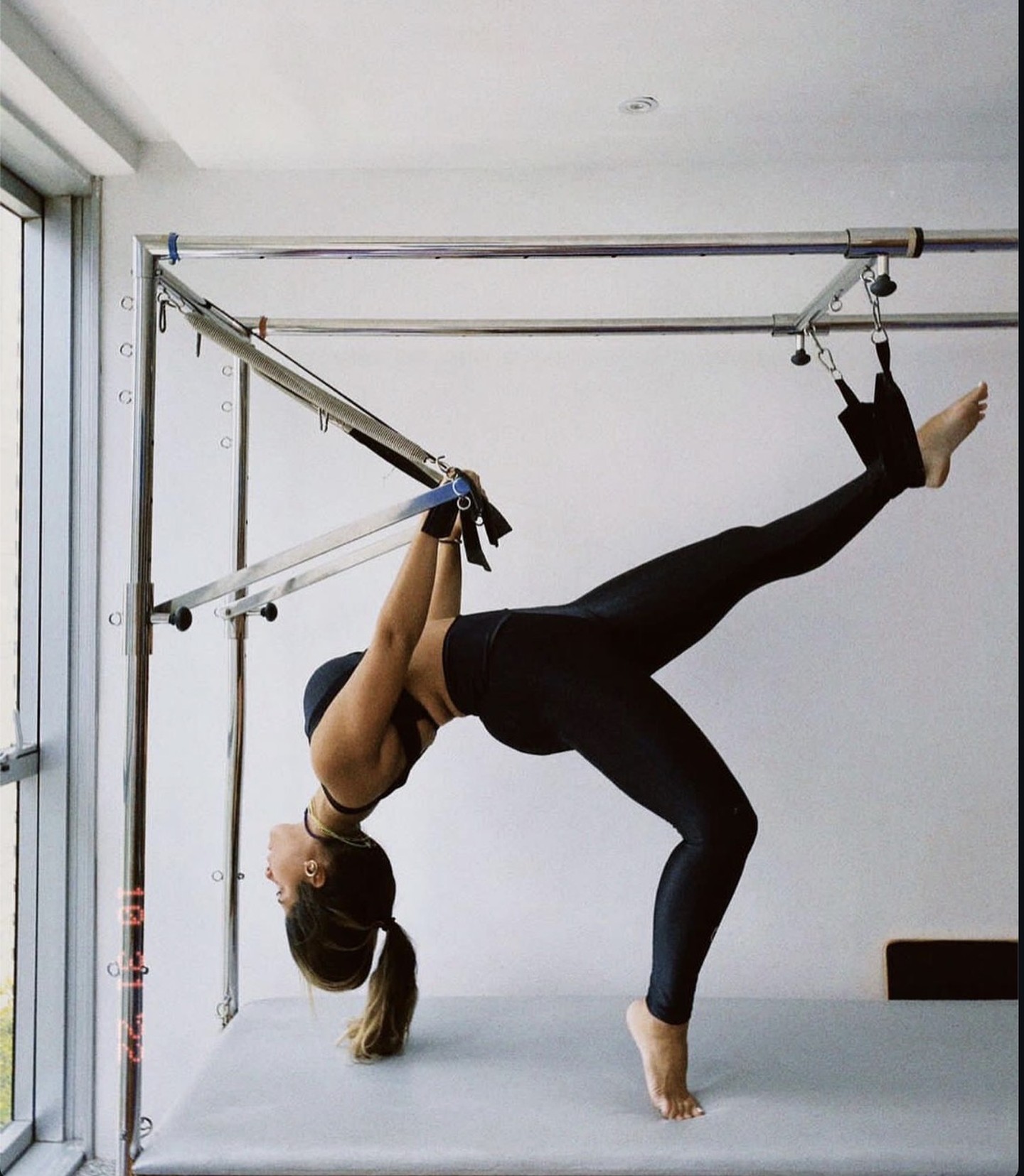 Prática de Pilates no Cadillac, com vista da janela do studio